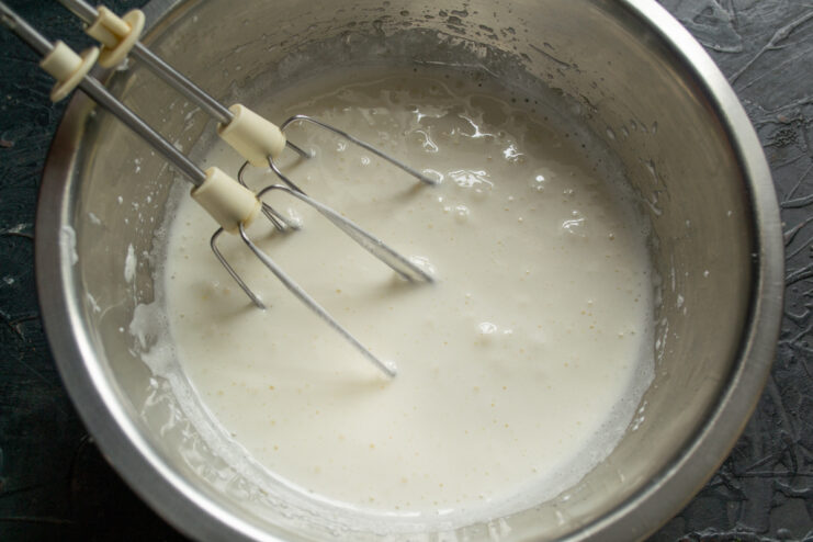 Whisking the egg mixture Fluffy whipped egg and sugar mixture with mixer beaters
