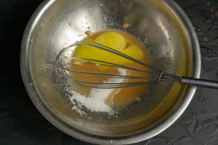 Preparing the yolks Whisking egg yolks and sugar in a bowl for the dough