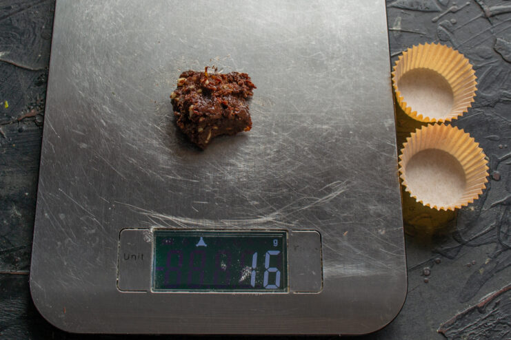 Weighing the truffle dough Portioning and weighing small 16-gram pieces of chocolate truffle dough on a digital scale