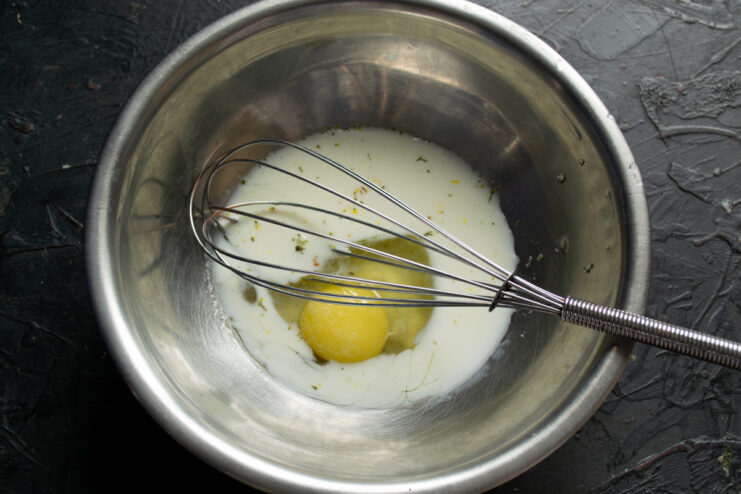 Preparing The Pancake Batter Base Whisking eggs, milk, and spices together in a mixing bowl