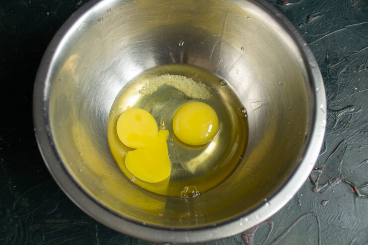 Eggs, salt, and sugar mixed in a deep bowl