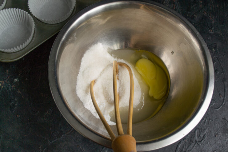 Egg and sugar mixed in a bowl with a wire whisk