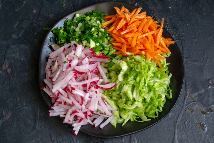 Bright julienned carrots on a dish with other vegetables
