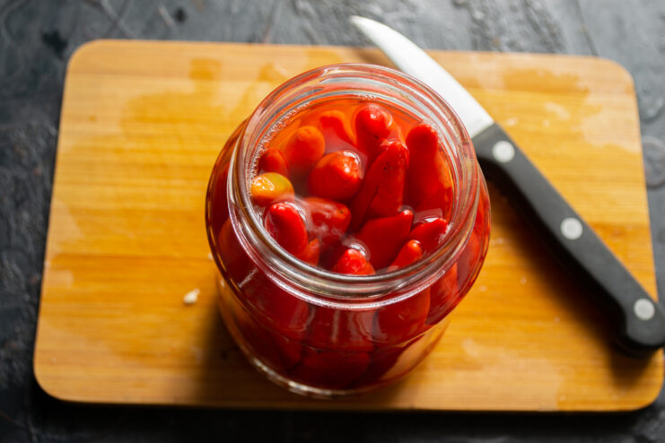 Warming the peppers Pouring boiling water over chili peppers inside a glass jar