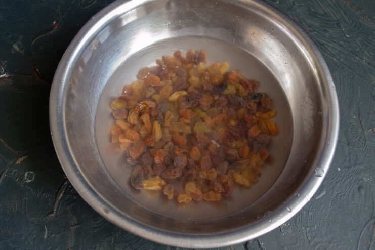 Preparing Raisins Soaking raisins in a metal bowl filled with water