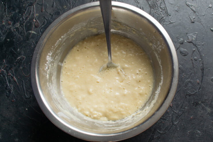 Thick mixed pancake batter inside a bowl with a spoon