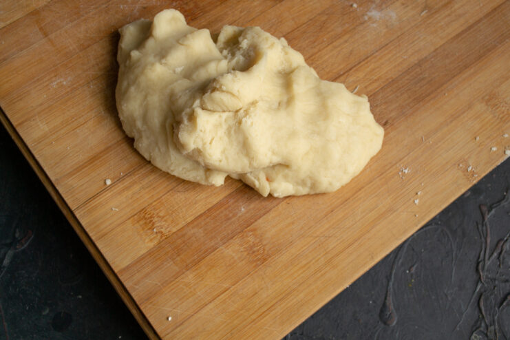 Kneading the hot dough Freshly kneaded warm dough resting on a wooden cutting board