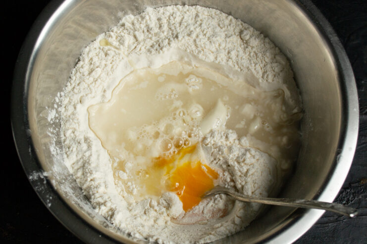 Making the dough Kneading noodle dough in a bowl with wheat flour and egg
