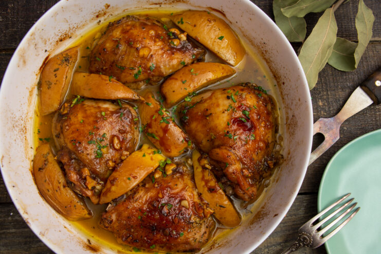 Roasted chicken with quince and apples in a white baking dish