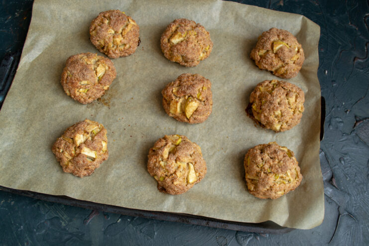 Golden baked buns resting on a baking sheet