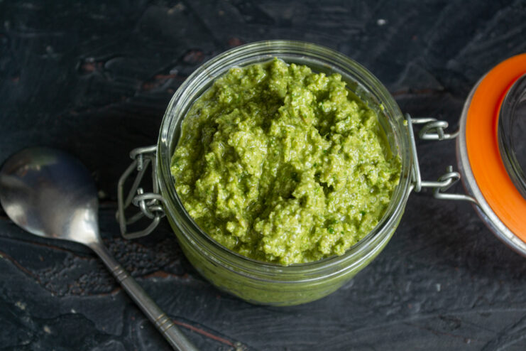 Storing the Pesto Top-down view of vibrant green pesto in an open glass jar