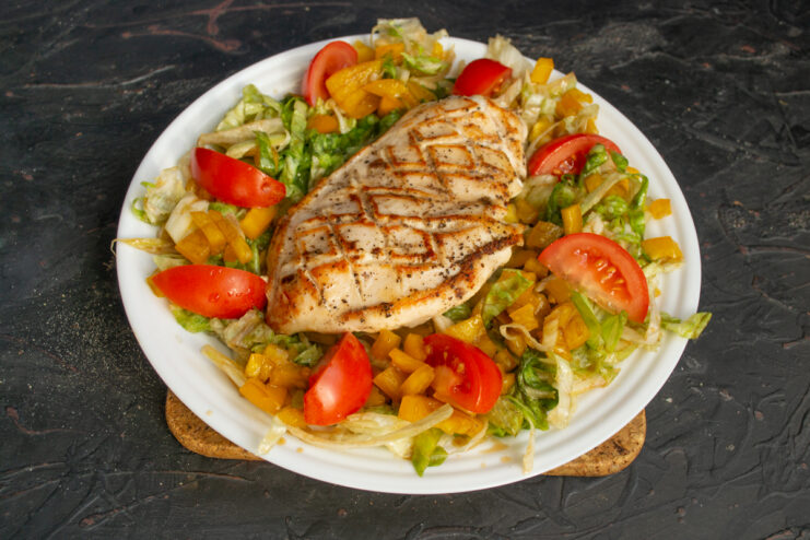 Adding the chicken Seared chicken fillet placed in the center of the vegetable salad