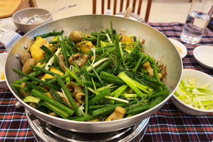 Sizzling cha ca fish with fresh dill Fried cha ca fish covered in fresh dill and green onions cooking in a skillet.