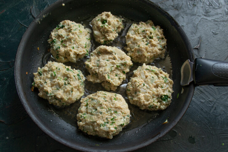Frying the Patties Shaped oat patties frying in a hot oiled skillet