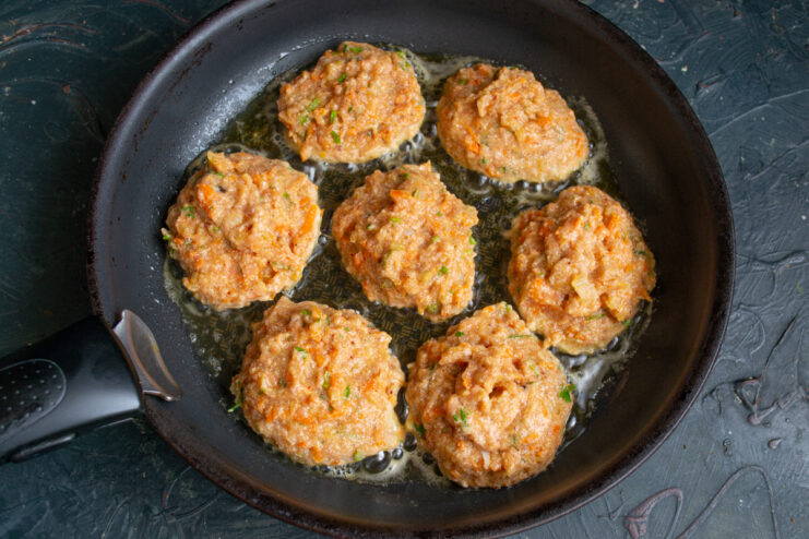 Frying salmon patties in a hot skillet with oil