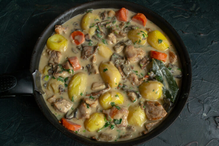 Adding the Sauce Pork and vegetables covered with creamy mushroom sauce and fresh parsley.