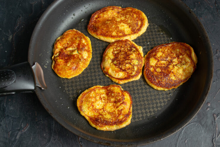 Frying The Second Side Golden brown potato fritters flipped over in a skillet
