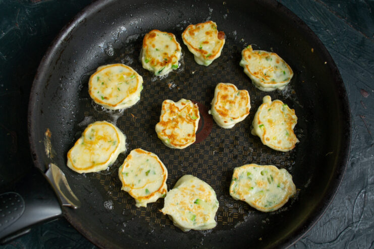 Golden brown pan-fried fritters in a skillet