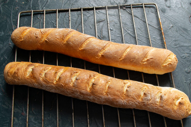 Golden baked baguettes cooling on a wire rack