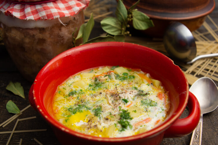 Appetizing quick soup with canned braised meat, potatoes, and vermicelli served in a red bowl.
