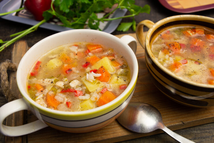 Appetizing chicken and rice soup with vegetables served in a ceramic bowl