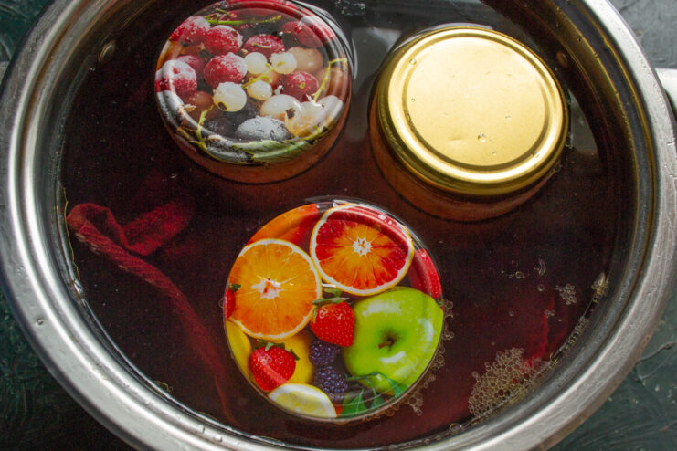Cooking the stew Glass jars fully submerged in boiling water inside a pot