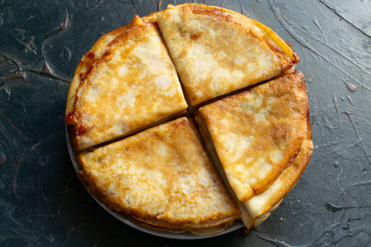Stack of golden folded crepes on a plate
