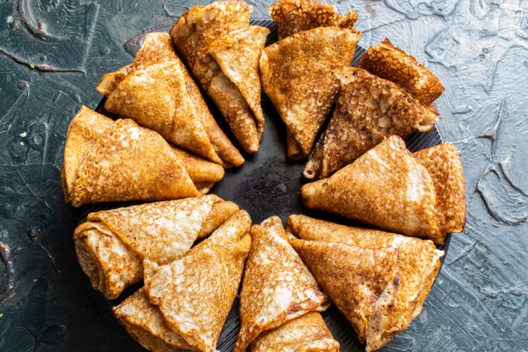 Folding crepes into cones Crepes folded into cones arranged on a black plate