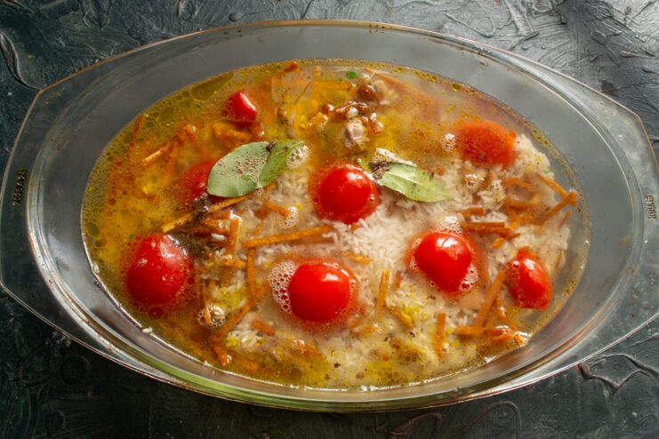 Baking dish filled with chicken, rice, and water ready to be covered in foil