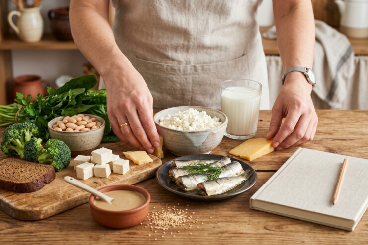 Meal Planning and Calcium Absorption Person planning a daily menu by selecting high-calcium ingredients like cheese, cottage cheese, fish, and fresh vegetables.