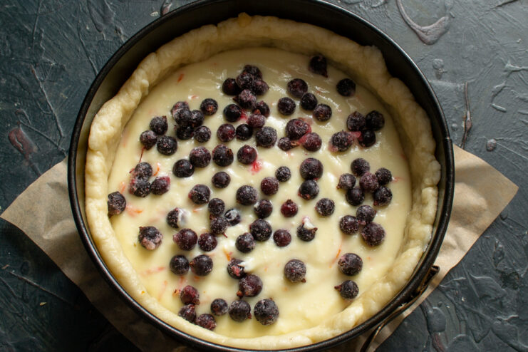 Blackcurrants scattered over the cheese layer of the galette
