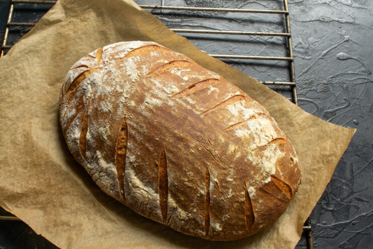 Freshly baked sourdough bread Whole baked loaf of sourdough bread resting on a cooling rack
