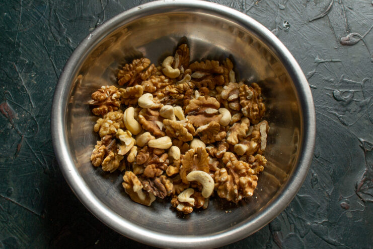 Nuts for biscotti Whole walnut and cashew kernels in a metal bowl