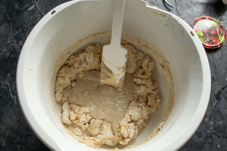 Adding active starter Active sourdough starter being added into the flour and liquid mixture
