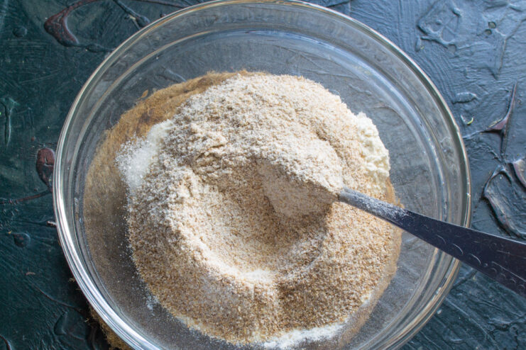 Adding the second type of flour Adding whole wheat flour into a mixing bowl