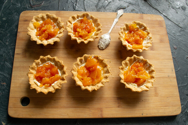 Fruit Layer Addition Adding fruit jam over buttercream inside tartlet shells
