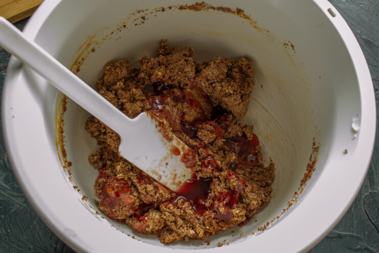 Adding fruit jam to the chocolate pastry mixture.