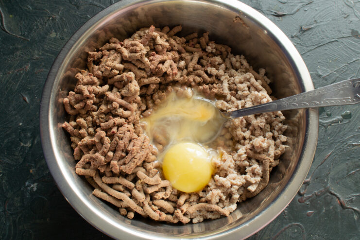 Adding Eggs Raw eggs added to the ground meat and liver mixture