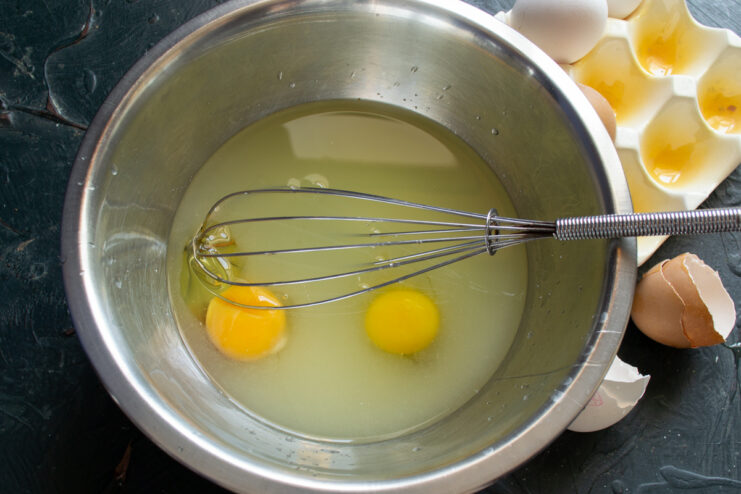 Adding eggs to milk whey in a bowl