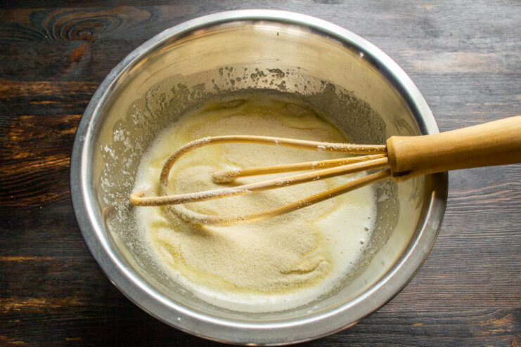 Adding semolina into the batter Pouring semolina into the liquid cake batter in a bowl