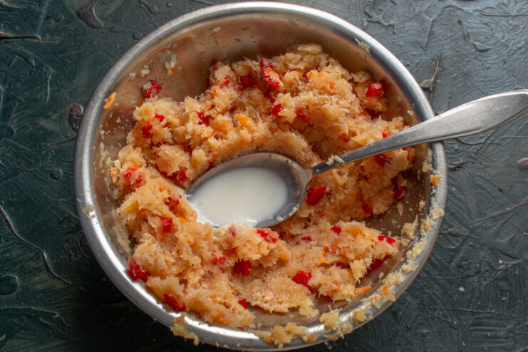 Adding milk to the ground fish mixture in a bowl