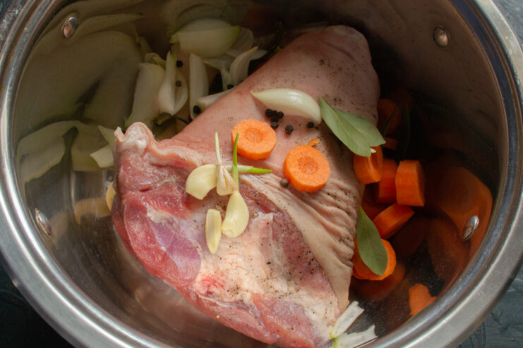 Vegetables for the Broth Adding carrots, onions, and spices to the meat pot.