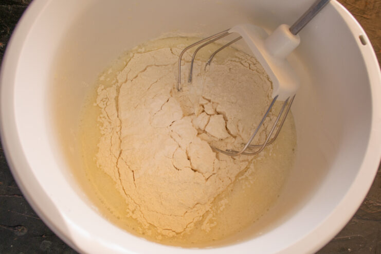 Adding dry ingredients to the dough Pouring flour and baking powder into the wet mixture