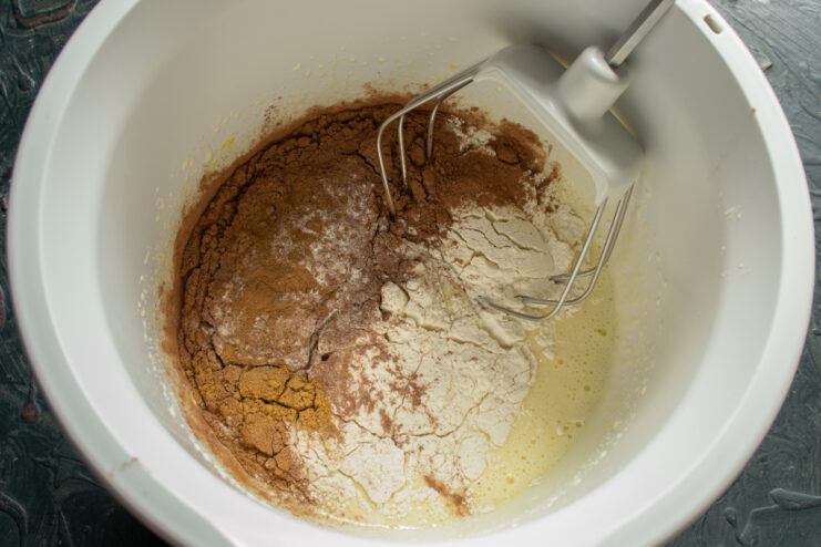 Adding flour, cocoa, and spices to the egg mixture.