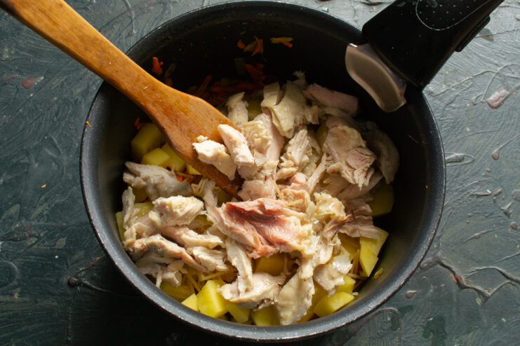 Adding canned braised meat Adding canned braised meat from a jar into the pot with the soup ingredients.