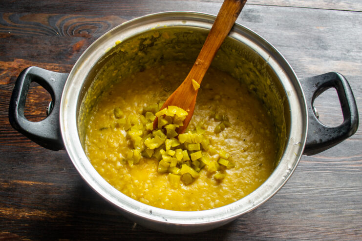 Folding diced fermented pickles into the simmering porridge
