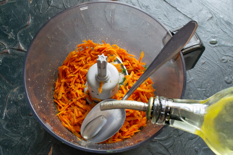 Seasoning pate with oil Pouring extra virgin olive oil into the food processor with pate ingredients