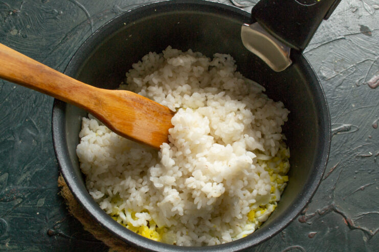 Rice For A Hearty Filling Adding cooked white rice to a pot with the crackling mixture