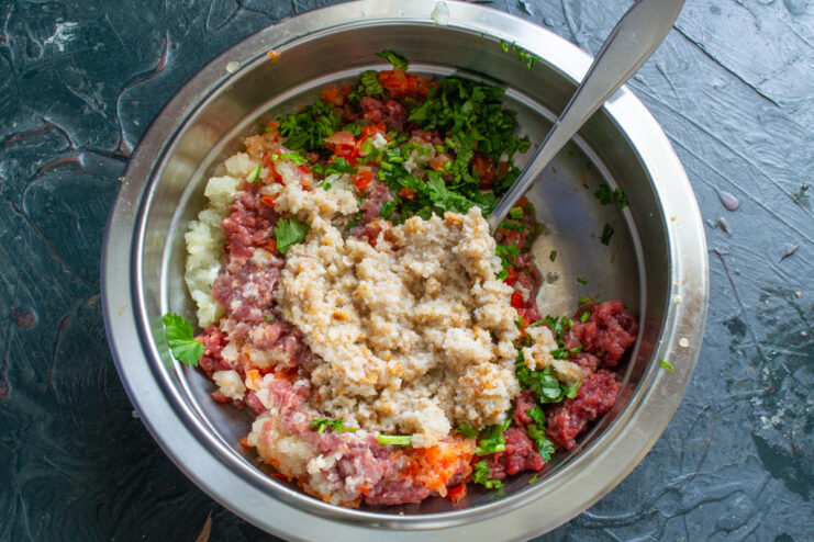 Soaked bread in the mixture Adding soaked white bread to the bowl of ground meat