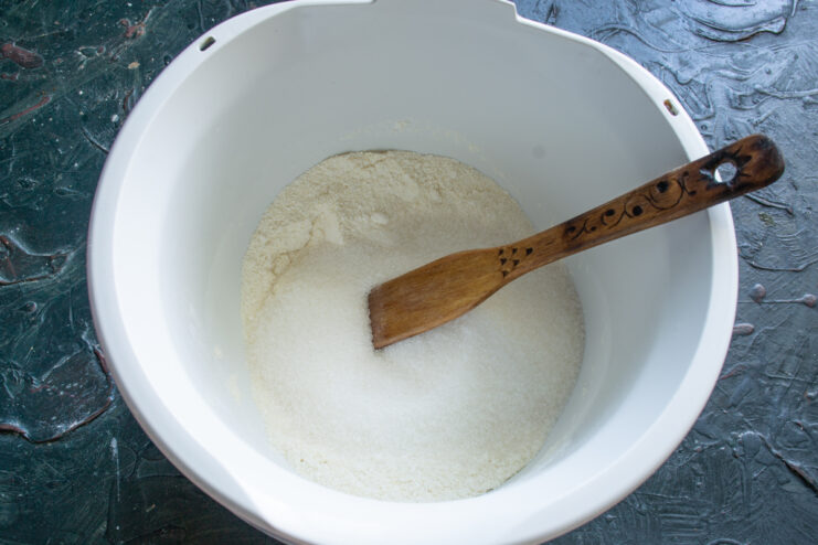 Adding Sugar And Vanilla Pouring granulated sugar and vanilla into the dry semolina mixture